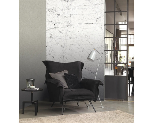 Wohnzimmer mit Sessel, Stehlampe, Beistelltisch und Marmortapete