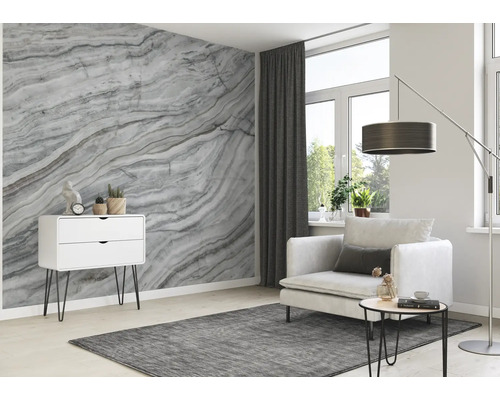 Wohnzimmer mit Marmortapete, Sessel, Teppich und Kommode