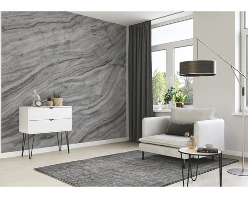 Salon avec papier peint marbré, fauteuil, commode et tapis pour une ambiance claire et moderne