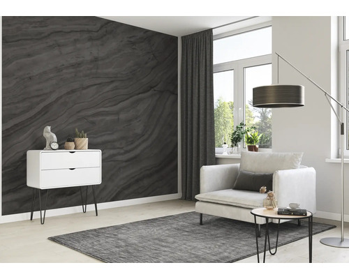 Salon avec papier peint gris imitation marbre, fauteuil, lampadaire et commode