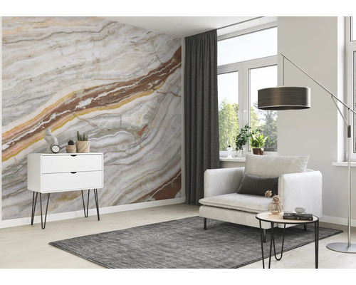 Wohnzimmer mit gemusterter Tapete, Sessel, Teppich und Kommode