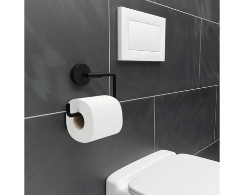 Porte-papier toilette en métal avec rouleau de papier toilette à côté d''une chasse d''eau de toilettes