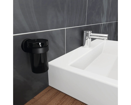 Gobelet noir pour brosse à dents, montage mural à côté d''un lavabo