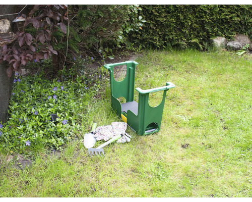 Scène de jardin avec tabouret de jardin, pelle, râteau et gants de jardin sur une pelouse