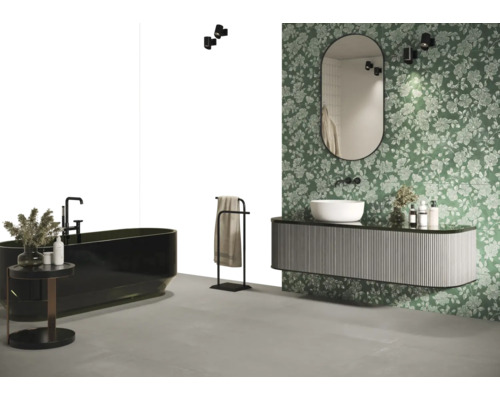 Helles Badezimmer mit Badewanne, Waschtisch, Spiegel, Handtuchhalter und floraler Tapete