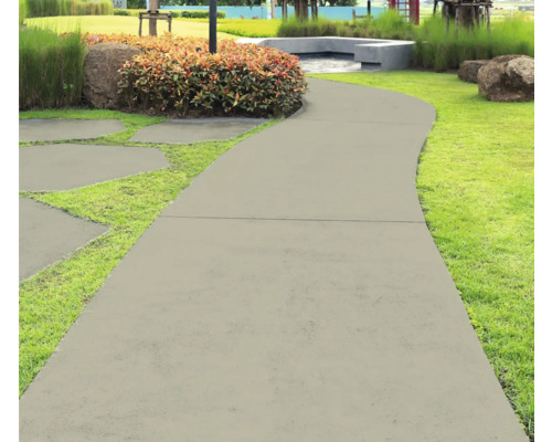 Gartenweg aus Betonplatten, umgeben von Gras und Pflanzen