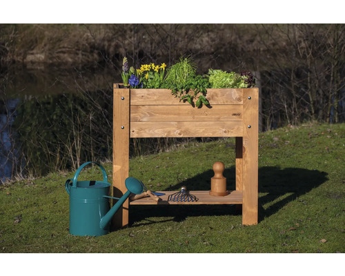 Jardinière sur pieds en bois avec fleurs, herbes et outils de jardinage