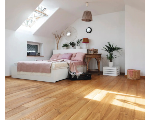 Chambre mansardée accueillante avec parquet et fenêtre de toit