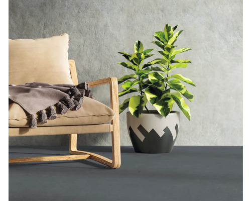 Sessel mit Kissen und Zimmerpflanze im Topf