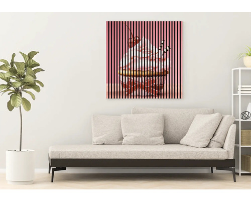 Toile décorative avec un motif de cupcake au-dessus d''un canapé dans un salon.