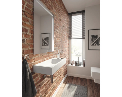 Salle de bain avec lavabo, miroir et mur de briques