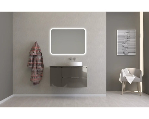 Modernes Badezimmer mit Waschtisch, beleuchtetem Spiegel, Bademantel und Stuhl