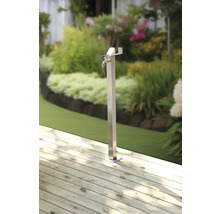Borne fontaine de jardin en métal sur terrasse en bois avec jardin en arrière-plan