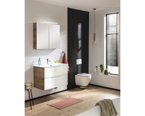 Salle de bain moderne avec lavabo, armoire de toilette, WC suspendu et mur d''accent foncé.