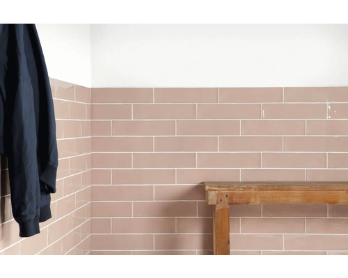 Mur carrelé avec des carreaux rectangulaires et un banc en bois