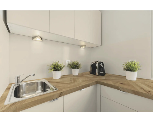 Küchenszene mit Spüle, Arbeitsplatte aus Holz, Küchenschränken und Beleuchtung