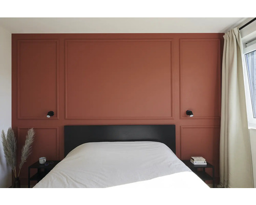 Chambre avec panneaux muraux, lit et tables de chevet.