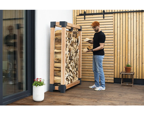 Étagère à bois de chauffage en bois avec du bois de chauffage et une personne tenant du bois