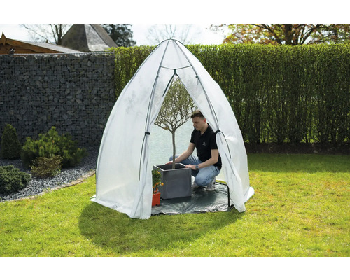 Scène de jardin avec tunnel en plastique pour protéger les plantes dans le jardin.