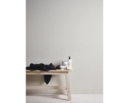 Wand mit Tapete, Hocker mit Handtuch und Pflegeprodukten