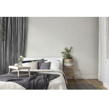 Helles Schlafzimmer mit Bett, Nachttisch, Pflanze und Vorhängen