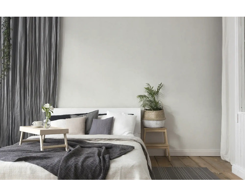 Helles Schlafzimmer mit Bett, Nachttisch, Pflanze und Vorhängen