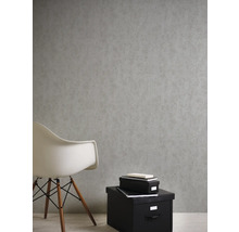 Papier peint gris aspect béton dans une pièce avec des sièges et des boîtes de rangement