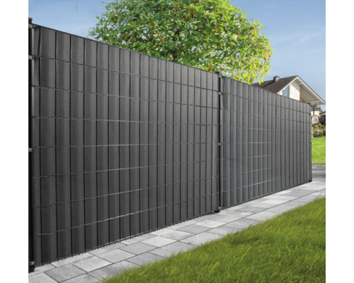Clôture de jardin sombre en plastique structuré devant des arbres