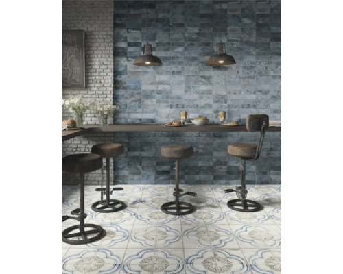 Scène de cuisine avec des carreaux muraux bleus, des carreaux de sol à motifs et des tabourets de bar.