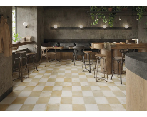 Gastraum mit Schachbrettmuster-Fliesenboden, Tischen und Stühlen.