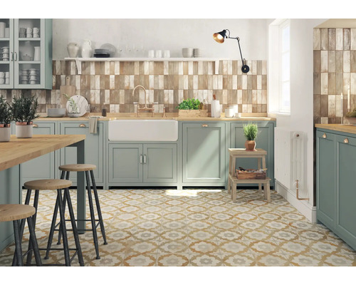 Cuisine claire avec armoires vert menthe, plans de travail en bois, carreaux rustiques et carreaux de sol à motifs floraux