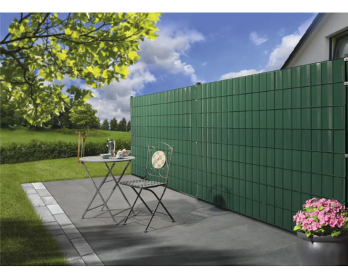 Scène de jardin avec pare-vue, table de jardin et chaise sur une terrasse