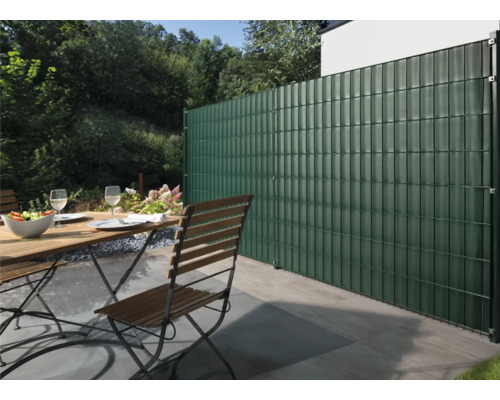 Jardin avec clôture en treillis soudé, table de jardin et chaises sur la terrasse