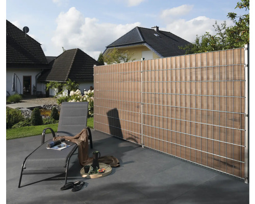 Scène de jardin avec clôture d''intimité, chaise longue et maison en arrière-plan