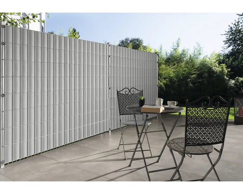 Clôture de confidentialité en plastique avec table et chaises sur une terrasse