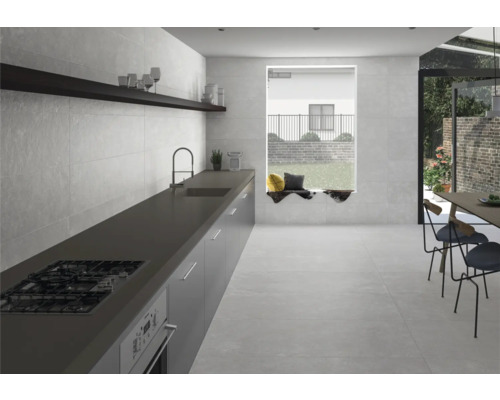 Cuisine lumineuse avec sol carrelé, kitchenette et coin repas.