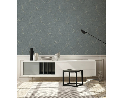 Wohnraum mit blaugrauer Tapete in Marmoroptik, Kommode, Hocker und Teppich