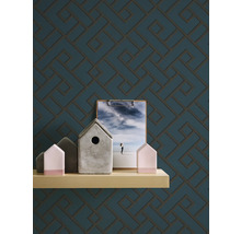 Dekoratives Wanddesign mit geometrischem Muster auf Tapete, ergänzt durch eine schmale Ablage mit Deko-Objekten.