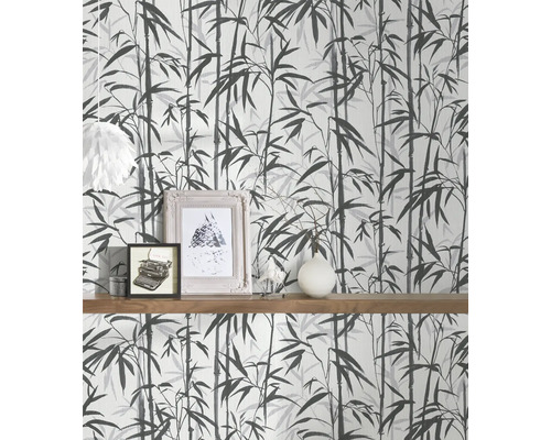 Tapete mit Bambusmuster an einer Wand mit Holzregal und Dekoration