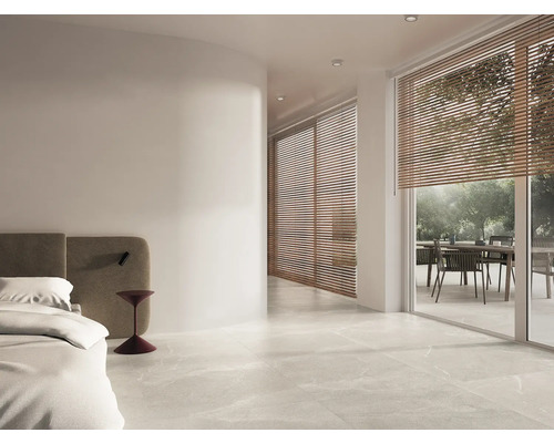 Chambre claire avec sol carrelé, lit et terrasse avec mobilier de jardin