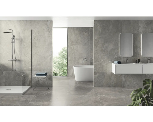 Helles Badezimmer mit Dusche, Badewanne, Waschbecken und Spiegeln vor grauen Fliesen