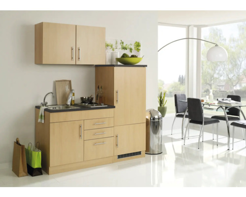 Cuisine compacte avec évier, plaque de cuisson et espace de rangement dans une pièce lumineuse.