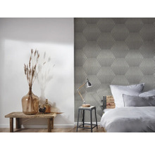 Chambre avec papier peint géométrique, tabouret en bois et décorations