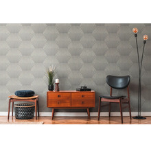 Salon avec papier peint à motifs, commode, chaise et lampadaire