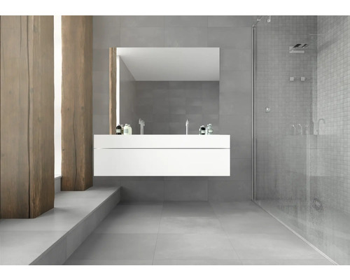 Helles Badezimmer mit Waschbeckenunterschrank, Spiegel und Dusche.