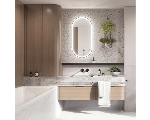 Badezimmer mit Waschtisch, beleuchtetem Spiegel, Hängepflanze und Badewanne