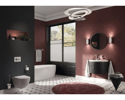 Badezimmer mit Toilette, Badewanne, Waschtisch, Spiegel, Lampe und Dekoration