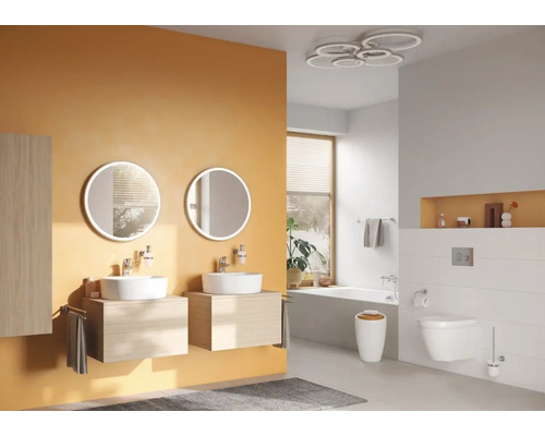 Salle de bains avec lavabos, miroirs ronds, toilettes et baignoire