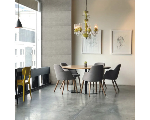 Coin repas avec table ronde en bois, chaises grises, lustre et fenêtre