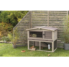 Clapier à lapin en bois indépendant à deux étages avec enclos extérieur dans le jardin.